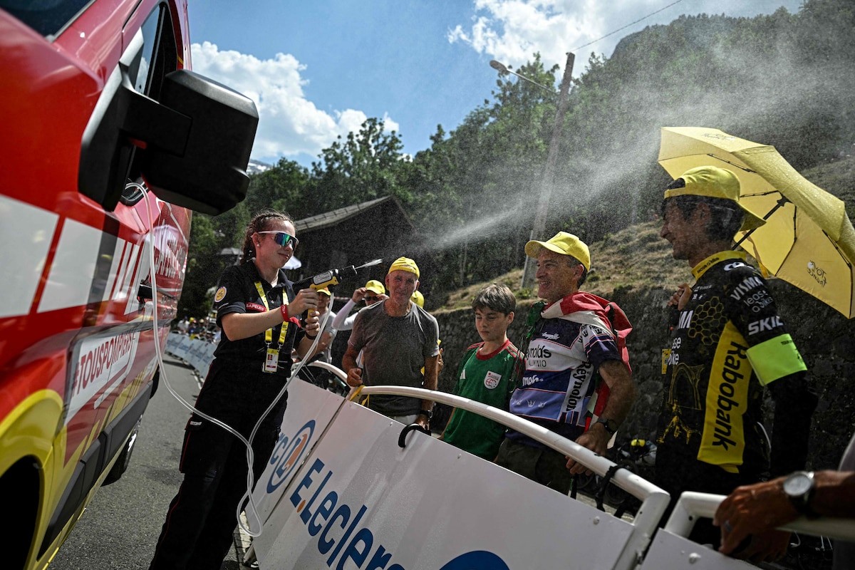 A firefighter spray water on spectators at the finish line amid a heatwave, during the 6th stage of the 113th edition of the Tour de France cycling race, 186 km between Pau and Gavarnie-G�dre in the French Pyrenees, on July 9, 2026. (Photo by Loic VENANCE / AFP)