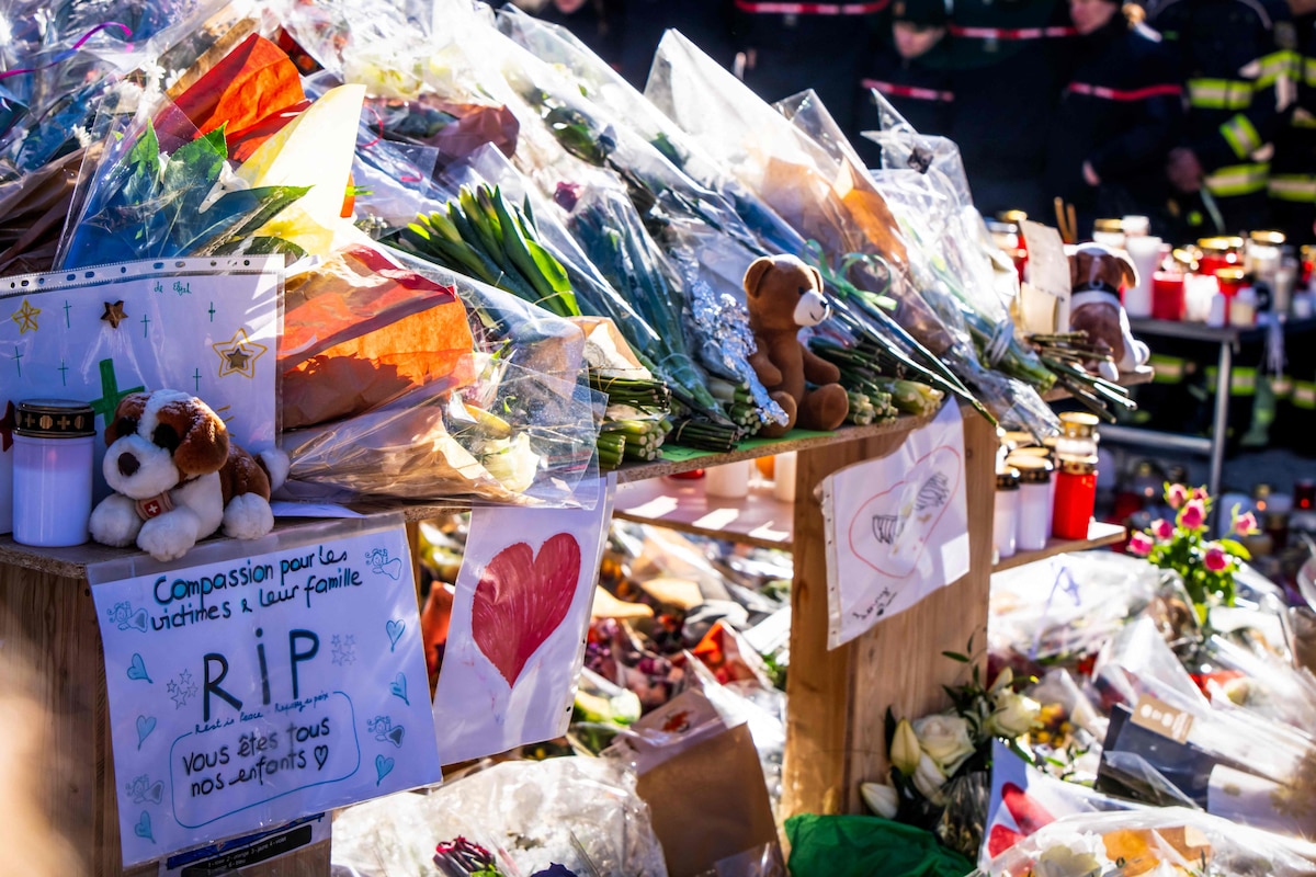 A photograph taken on January 4, 2026 shows flowers and messages layed at a makeshift memorial near the Constellation bar, in Crans-Montana in honour of the victims of the fire that ripped through the venue in the luxury Alpine ski resort on New Year's Eve. Authorities investigating the New Year's blaze in the Swiss resort of Crans-Montana have identified 24 of the 40 people killed, including 11 minors and six foreign nationals, police said on January 4, 2026. Also 119 were injured during the fire, most of them seriously, according to the latest toll. (Photo by MAXIME SCHMID / AFP)