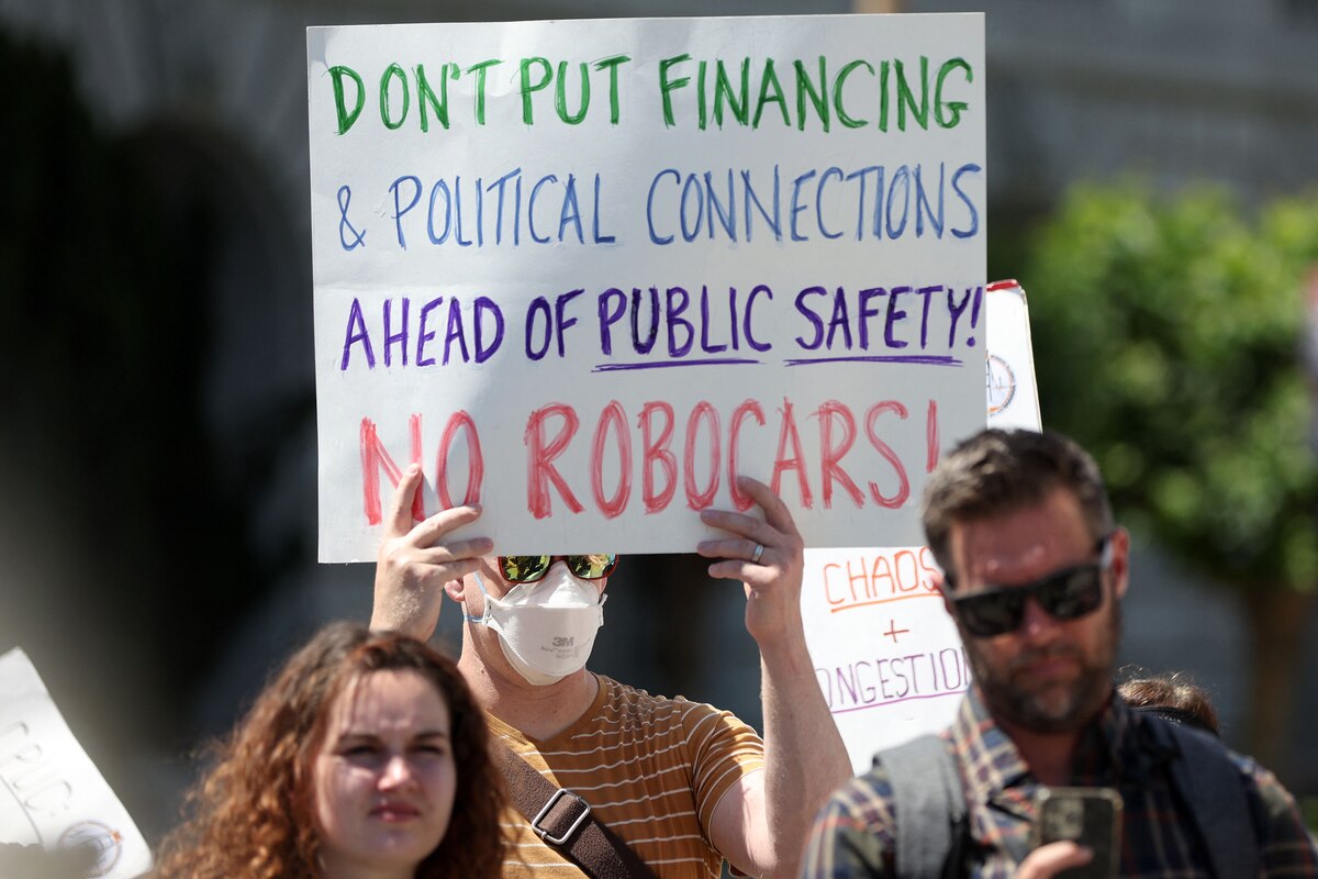SAN FRANCISCO, CALIFORNIA - AUGUST 07: A protester holds a sign during a demonstration outside of the California Public Utilities Commission (CPUC) on August 07, 2023 in San Francisco, California. San Francisco taxi drivers and opponents of autonomous vehicles are protesting the CPUC's pending approval of driverless taxi companies Waymo and Cruise's applications for citywide 24/7 commercial driverless passenger service despite hundreds of complaints about the autonomous vehicles causing hazardous incidents and street blockages throughout the city. The CPUC will vote on August 10th to allow Waymo and Cruise to expand their fleets in San Francisco. Justin Sullivan/Getty Images/AFP (Photo by JUSTIN SULLIVAN / GETTY IMAGES NORTH AMERICA / Getty Images via AFP)
