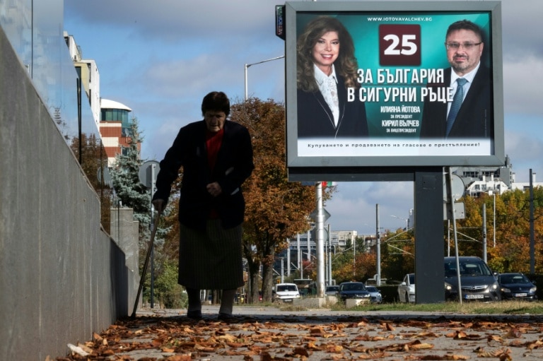 <p>Une personne marche devant une affiche électorale de la présidente sortante de Bulgarie, Iliana Iotova, et de son vice-président candidat Kiril Valchev, à Sofia, le 23 octobre 2026</p>