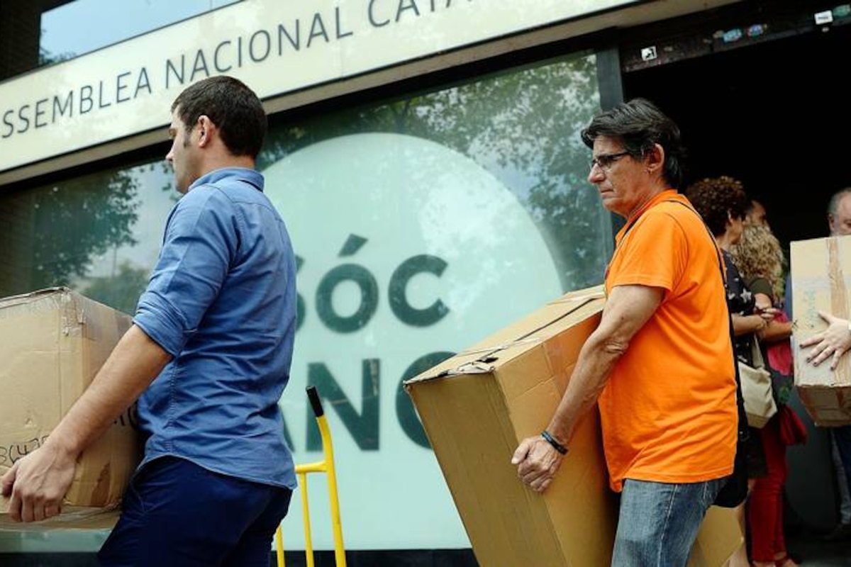 People leave the Catalan National Assembly (ANC) headquarters carrying boxes in Barcelona on September 22, 2017. Spain's conservative government has dealt a serious blow to Catalonia's plans to hold an independence referendum but it faces growing indignation in the region, which is closing ranks on Madrid. Following the arrest of 14 Catalan government officials and the seizure of nearly 10 million ballots, Catalonia's vice president Oriol Junqueras acknowledged that the referendum slated for October 1 was compromised. / AFP PHOTO / Josep LAGO