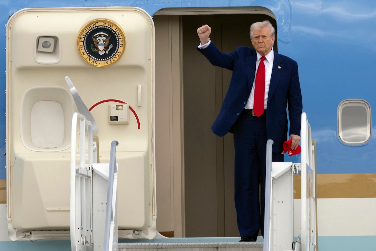 President Donald Trump pumps his fist as he arrives on Air Force One at Miami International Airport, Thursday, April 3, 2025, in Miami. (Al Diaz/Miami Herald via AP)