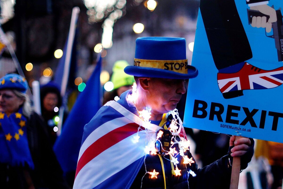TOPSHOT - Anti-Brexit protestors stand outside the Houses of Parliament in London on March 12, 2019, ahead of the second meaningful vote on the government's Brexit deal. - Prime Minister Theresa May's Brexit deal faced a likely defeat in an historic parliamentary vote Tuesday that risked pitching Britain into the unknown just 17 days before its scheduled split from the European Union. (Photo by Tolga AKMEN / AFP)