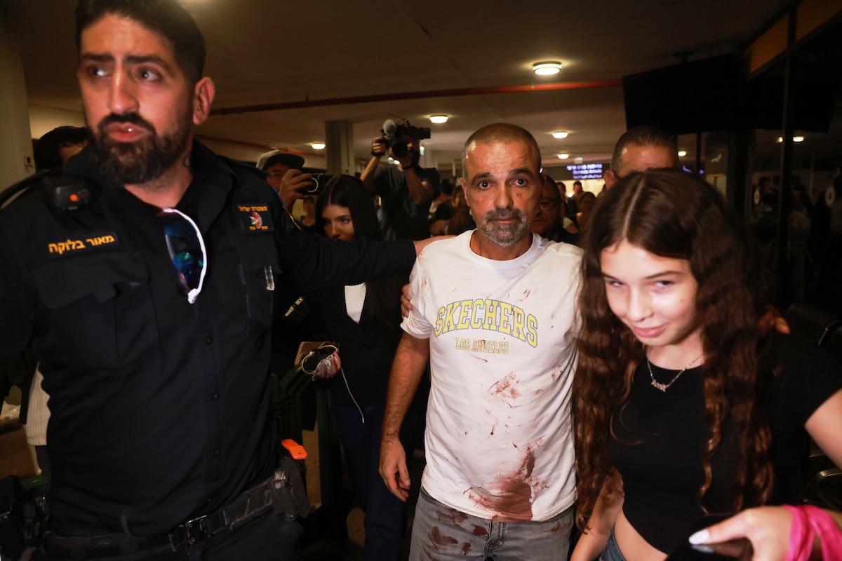 Israeli passenger Yaniv Hayoun, with blood stains on his shirt, who was aboard a Flydubai aircraft that made an emergency landing in Saudi Arabia, is welcomed at the arrivals gate at Ben Gurion International Airport near Tel Aviv, Israel, Wednesday, Sept. 30, 2026. (AP Photo/Tomer Appelbaum)