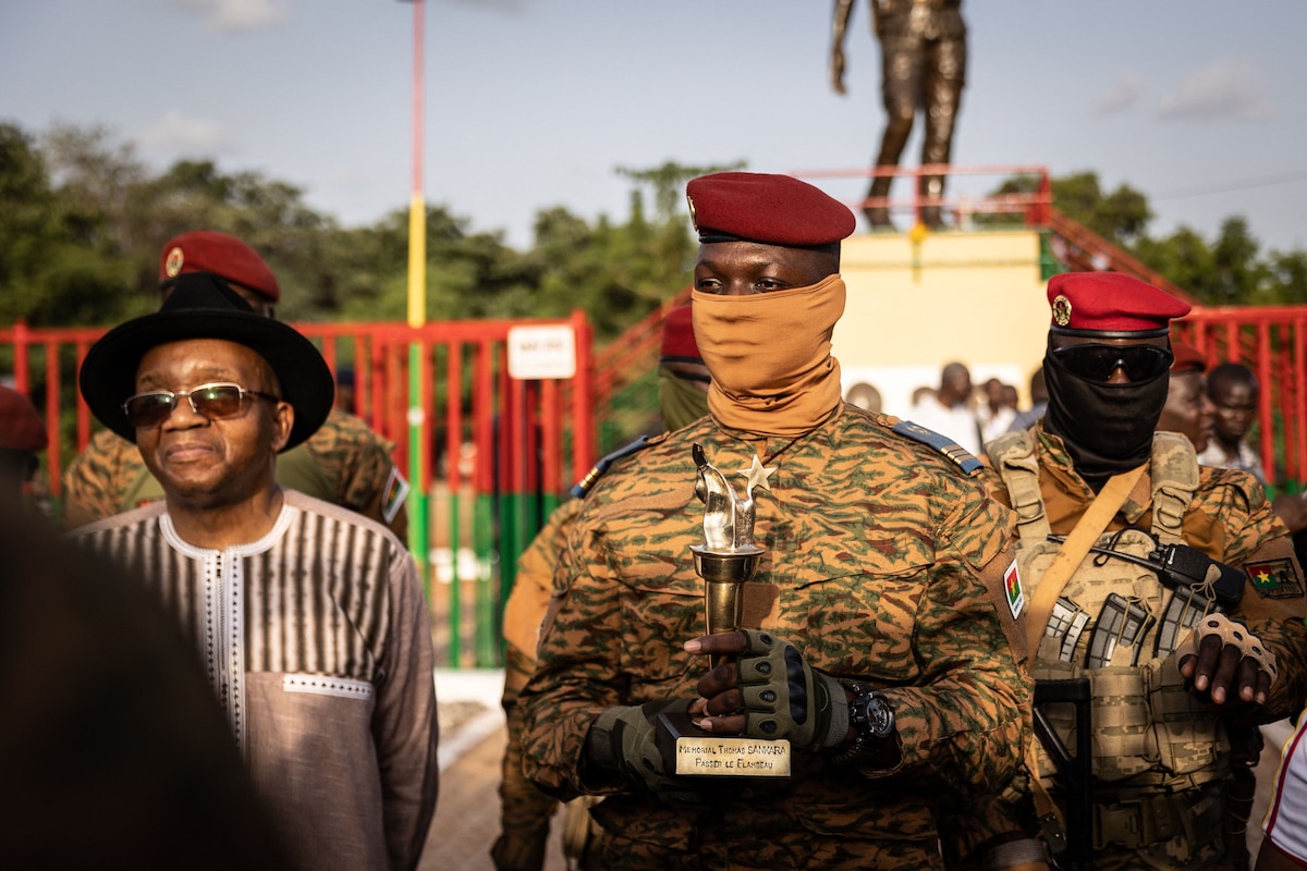 Captain Ibrahim Traore, Burkina Faso's new president, poses with the torch given by elders revolutionary during the ceremony for the 35th anniversary of Thomas Sankara�s assassination, in Ouagadougou, on October 15, 2022. - Captain Ibrahim Traore, who took power a fortnight ago in a coup in Burkina Faso, attended a ceremony on October 15, 2022 to mark the 35th anniversary of the assassination of revolutionary president Thomas Sankara, an AFP reporter noted. (Photo by OLYMPIA DE MAISMONT / AFP)