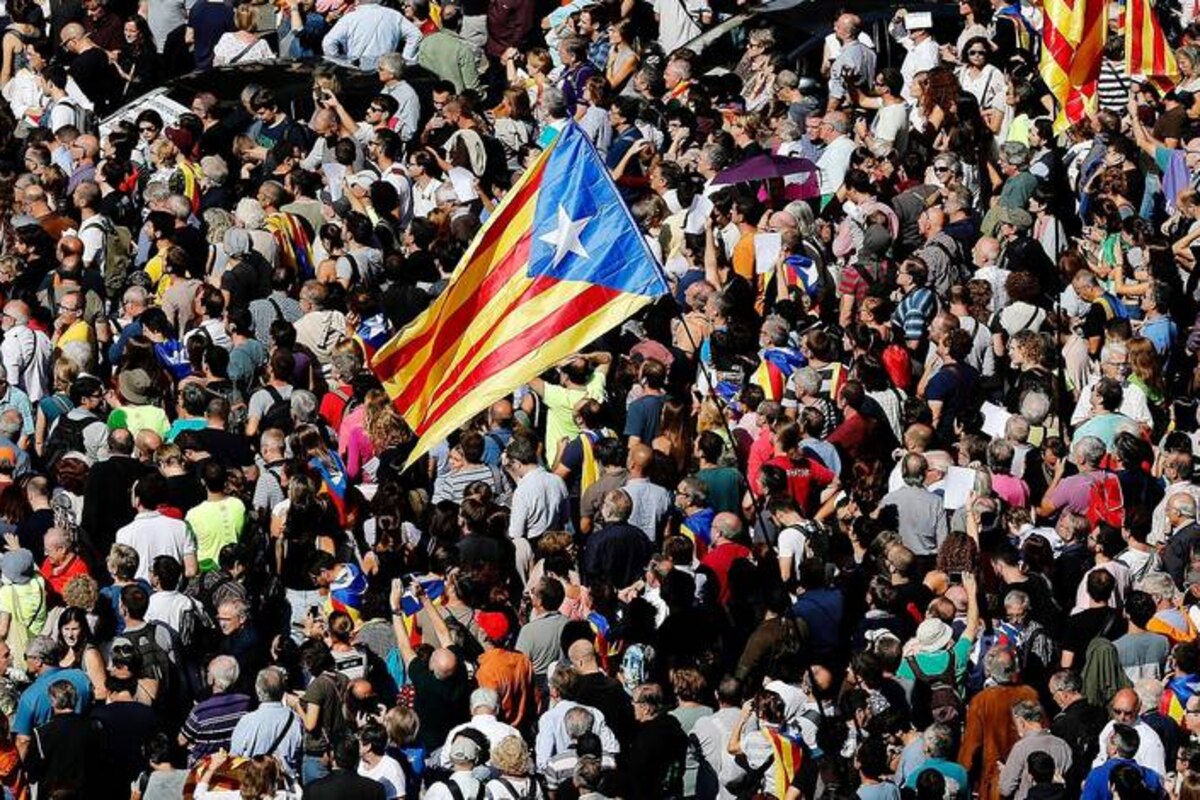 TOPSHOT - People holding 'Esteladas' (Catalan pro-independence flags) attend a protest near the Economy headquarters of Catalonia's regional government in Barcelona on September 20, 2017. Spain's Guardia Civil police arrested a top Catalan government official as part of raids on several Catalan government offices, sparking protests in Barcelona. The operation comes amid mounting tensions as Catalan leaders press ahead with preparations for an independence referendum on October 1 despite Madrid's ban and a court ruling deeming it illegal. / AFP PHOTO / PAU BARRENA