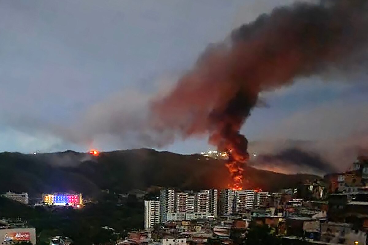 Fire at Fuerte Tiuna, Venezuela's largest military complex, is seen from a distance after a series of explosions in Caracas on January 3, 2026. The United States military was behind a series of strikes against the Venezuelan capital Caracas on Saturday, US media reported. The White House and Pentagon have not commented on the explosions and reports of aircraft over the city. US media outlets CBS News and Fox News reported unnamed Trump administration officials confirming that US forces were involved. (Photo by AFP)