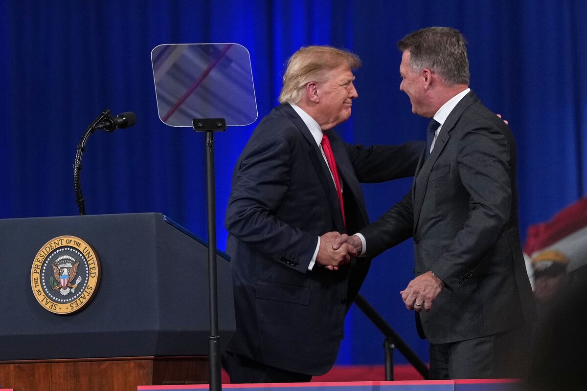 President Donald Trump greets Gernot Döllner, CEO of Audi AG, at a campaign rally at Guardian Centers of Georgia, Saturday, Oct. 24, 2026, in Perry, Ga. (AP Photo/Mark Schiefelbein)