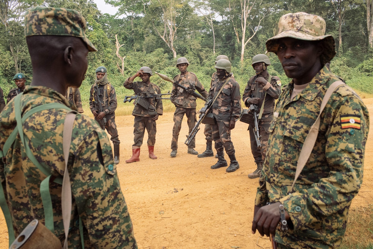 Soldiers from the 214th DP Battalion of the Armed Forces of the DRC (background) and soldiers from the Ugandan People's Defense Forces (UPDF) jointly engaged in Operation Shujaa in the region, on a road between Bulongo and Beni, North Kivu, in the east of the Democratic Republic of Congo, on December 17, 2024. Cocoa, the main economic resource in the DRC's Beni territory, is fuelling the violence in this northern part of North Kivu province, where there are no minerals. For several years, farmers have been the targets of looting and massacres committed by the ADF (Allied Democratic Forces) rebels, who have pledged allegiance to the Islamic State and sell the stolen goods in neighbouring countries. At the end of 2021, Uganda, one of the main cocoa producers on the continent, sent its troops to the region to work alongside the Congolese army against the ADF, an operation that raises questions about Kampala's ambitions for the sector. (Photo by PHIL�MON BARBIER / AFP)